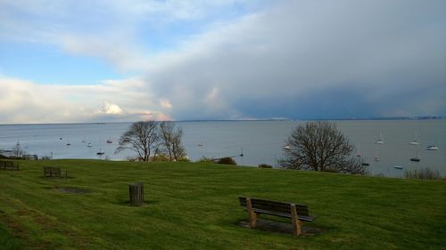 Scenic view of grassy field against cloudy sky