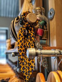 Close-up of spools in jar with scarf on shelf