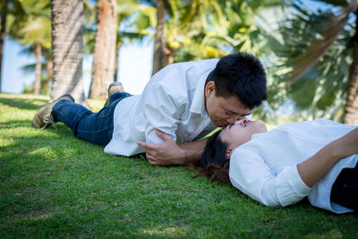 Side view of young man lying on grass