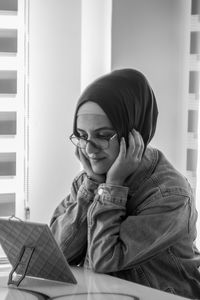 Portrait of smiling girl sitting on book