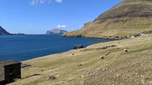 Scenic view of sea and mountains against blue sky