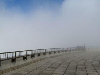 Vanishing pathway against sky during foggy weather