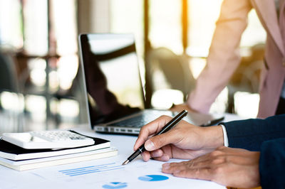 Midsection of man using laptop on table