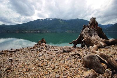 Scenic view of lake by mountain against sky