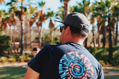 Rear view of man wearing mask against trees