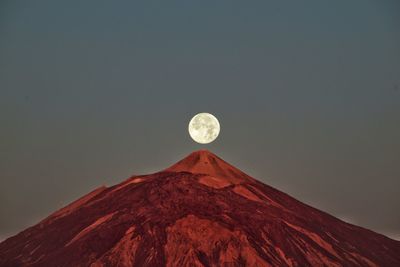 Low angle view of majestic mountain against sky at dusk