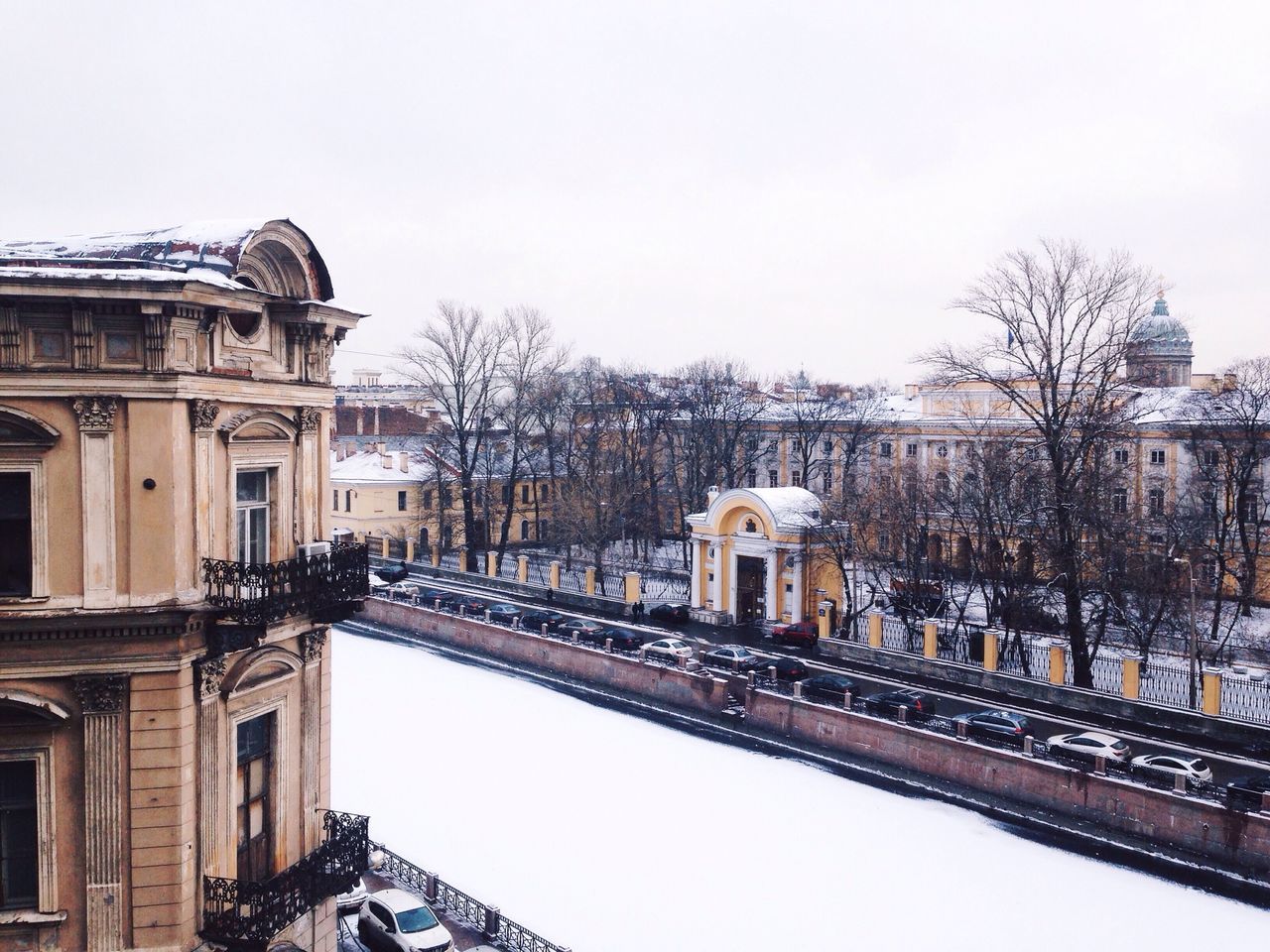 architecture, built structure, building exterior, winter, snow, cold temperature, clear sky, bare tree, tree, season, weather, railroad track, transportation, day, city, residential building, outdoors, sky, covering, rail transportation