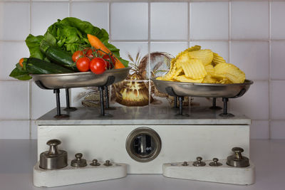 Close-up of potato chips and various vegetables on weight scale