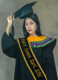 Portrait of woman standing against wall