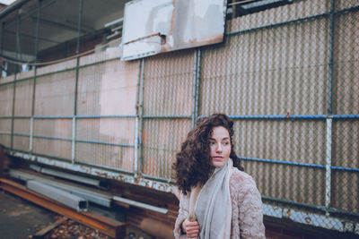 Woman standing against fence