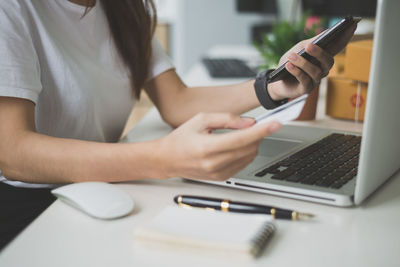 Midsection of woman using mobile phone