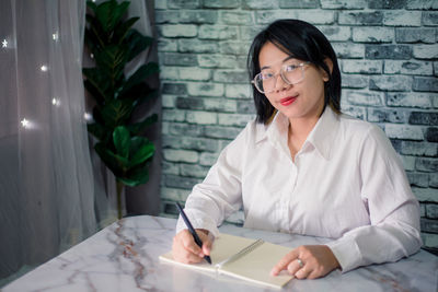 Handsome young smiling businesswoman working at home with laptop on desk