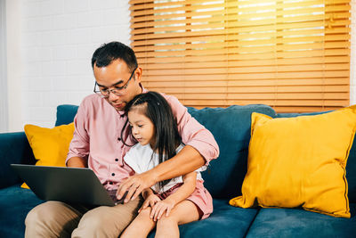 Doctor using laptop while sitting at home