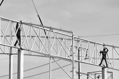 Low angle view of man on bridge against sky