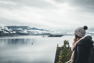 Rear view of person looking at snowcapped mountain against sky