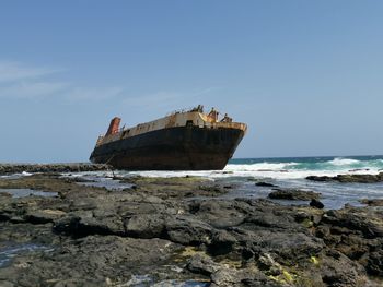 Nautical vessel on sea shore against sky