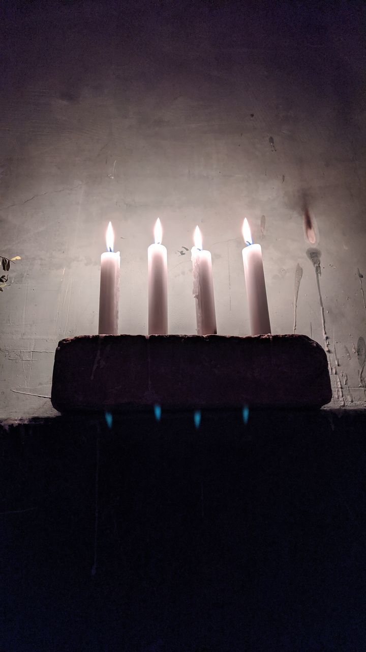 CLOSE-UP OF CANDLES ON WALL