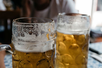 Close-up of beer glasses on table