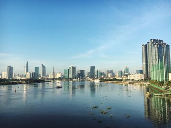 Sea and buildings in city against sky