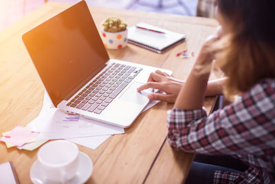 Midsection of woman using laptop at office