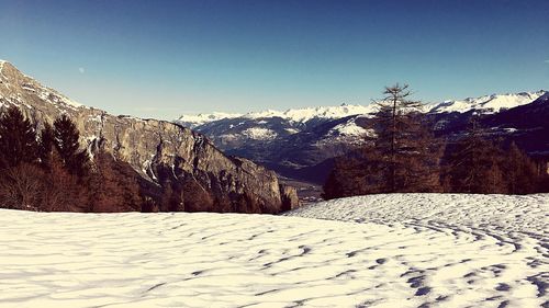 Scenic view of snowcapped mountains against clear sky