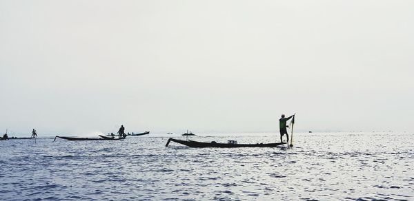 People on sea against sky