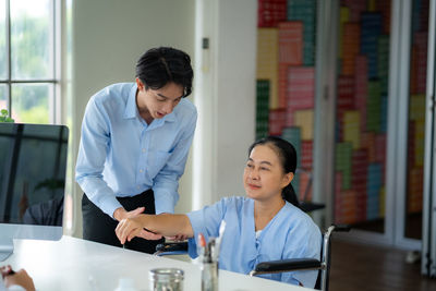 Side view of young woman working at table