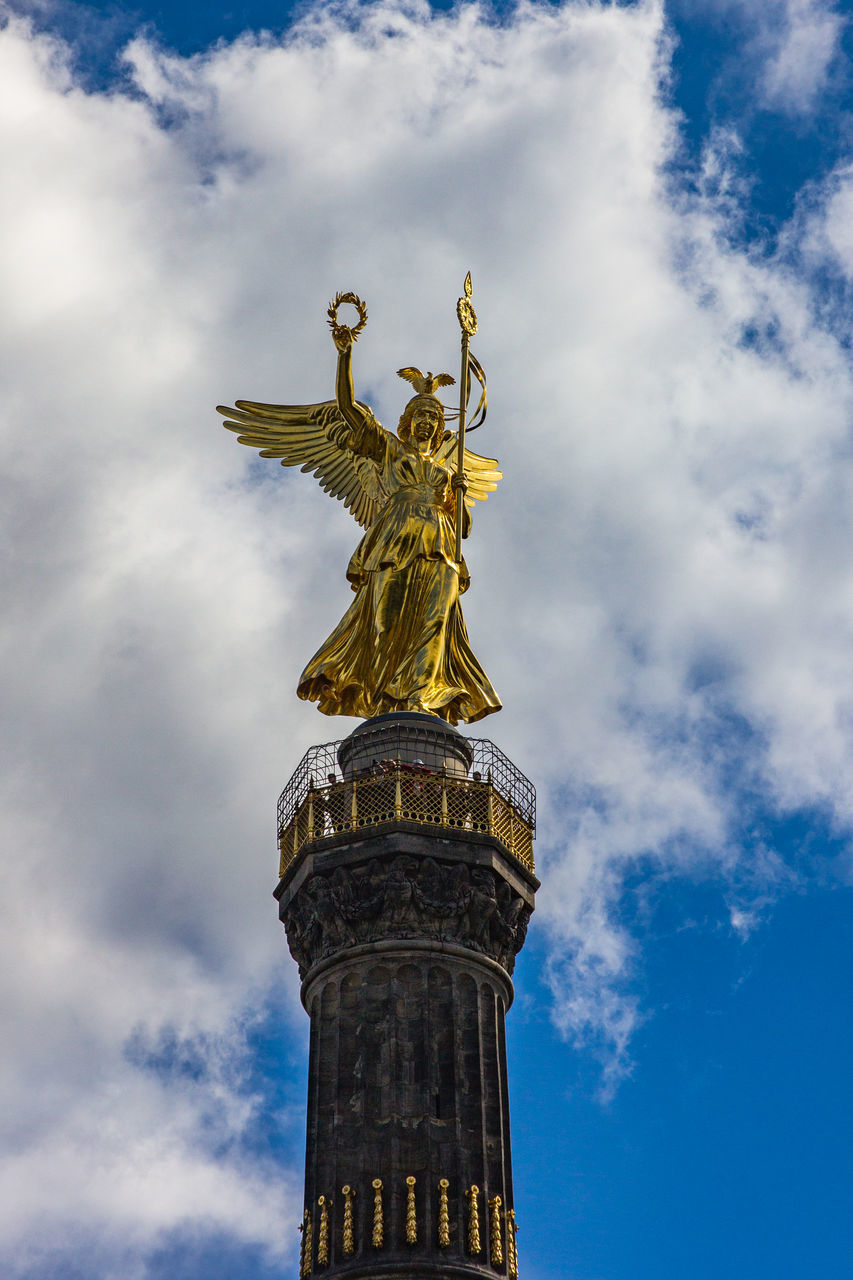 architecture, sky, cloud, statue, sculpture, travel destinations, city, history, the past, nature, travel, built structure, low angle view, gold, blue, human representation, no people, tourism, memorial, representation, day, monument, landmark, building exterior, outdoors, craft, tower