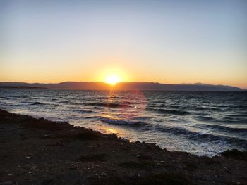 Scenic view of beach against clear sky during sunset