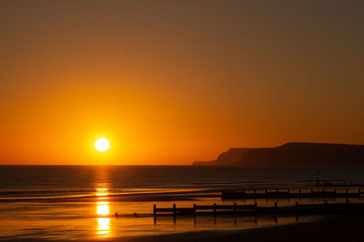 Scenic view of sea against orange sky