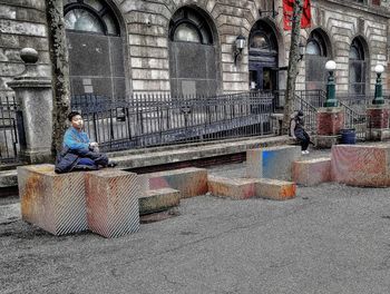 Full length of man sitting outdoors