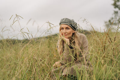 Portrait of young woman sitting on field