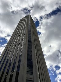 Low angle view of modern building against cloudy sky