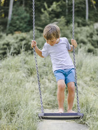 Full length of boy on swing at playground