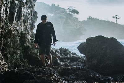 Man standing on rock against mountains