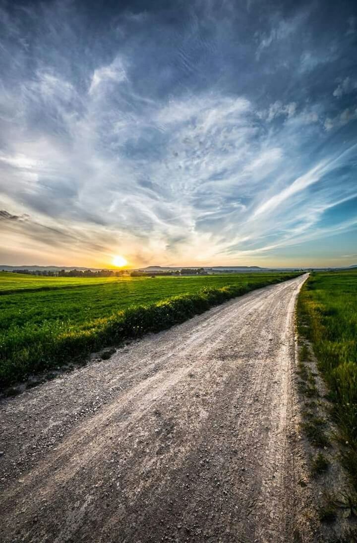 the way forward, sky, landscape, road, diminishing perspective, field, tranquil scene, country road, tranquility, cloud - sky, vanishing point, grass, transportation, rural scene, dirt road, nature, scenics, cloudy, beauty in nature, cloud