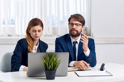 Man and woman using smart phone at table