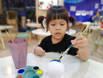 High angle view of girl painting on table