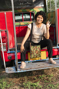 Portrait of smiling young woman standing against graffiti