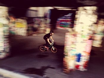 Blurred motion of man riding bicycle on road