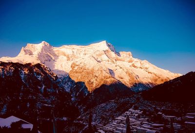 Scenic view of snowcapped mountains against clear blue sky