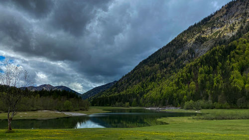 Scenic view of lake by mountains against sky