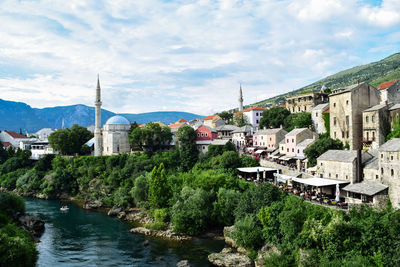 River amidst buildings in town against sky