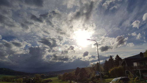 Low angle view of street amidst field against sky