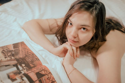 High angle view of young woman lying on bed at home