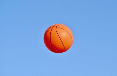 Low angle view of basketball against clear blue sky