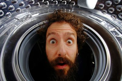 Close-up portrait of shocked man in washing machine