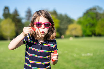 Portrait of boy wearing sunglasses standing on field