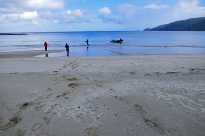 People on beach against sky