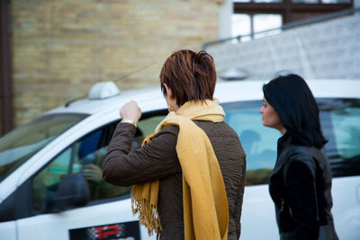 Rear view of women standing in car